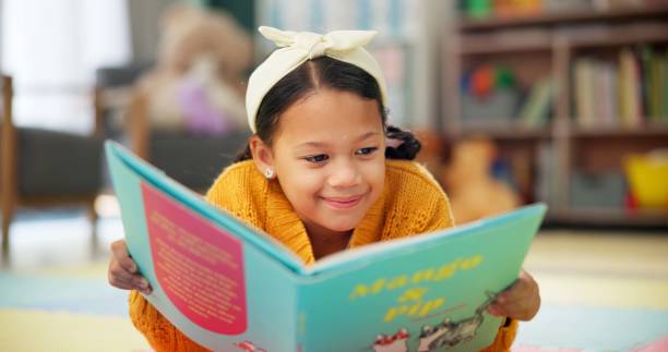 girl, school and reading book in class, childhood development and growth for vocabulary in kindergarten. happy, smile and knowledge or information with storybook, learning and fantasy for child - 그림책 뉴스 사진 이미지