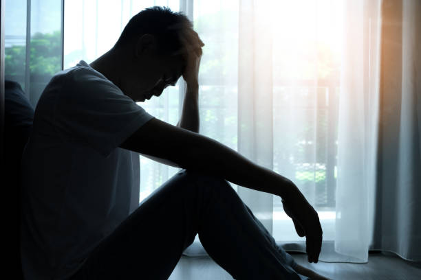 the man sitting in the corner of the room has emotional and mental problems he has depression and stress from society and work. medical concept. - 우울증 뉴스 사진 이미지